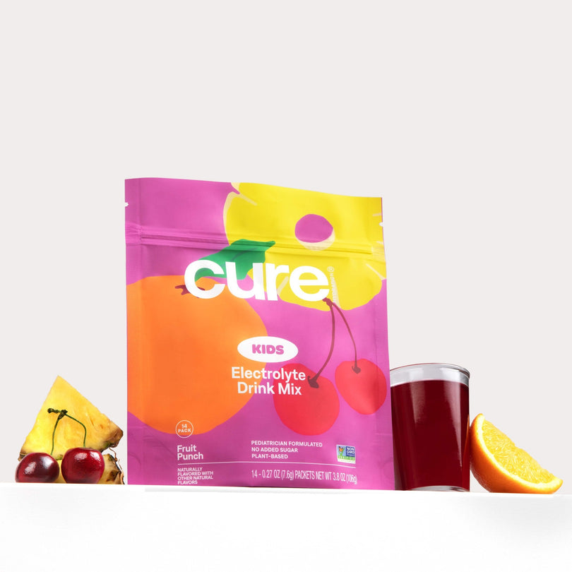 Cure Kids Electrolyte Drink Mix Fruit Punch package with pineapple, cherries, a glass of red drink, and an orange slice