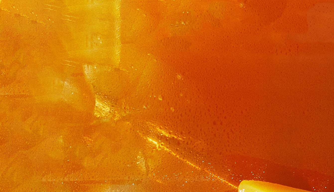 Close-up of an orange carbonated beverage with visible bubbles and condensation.