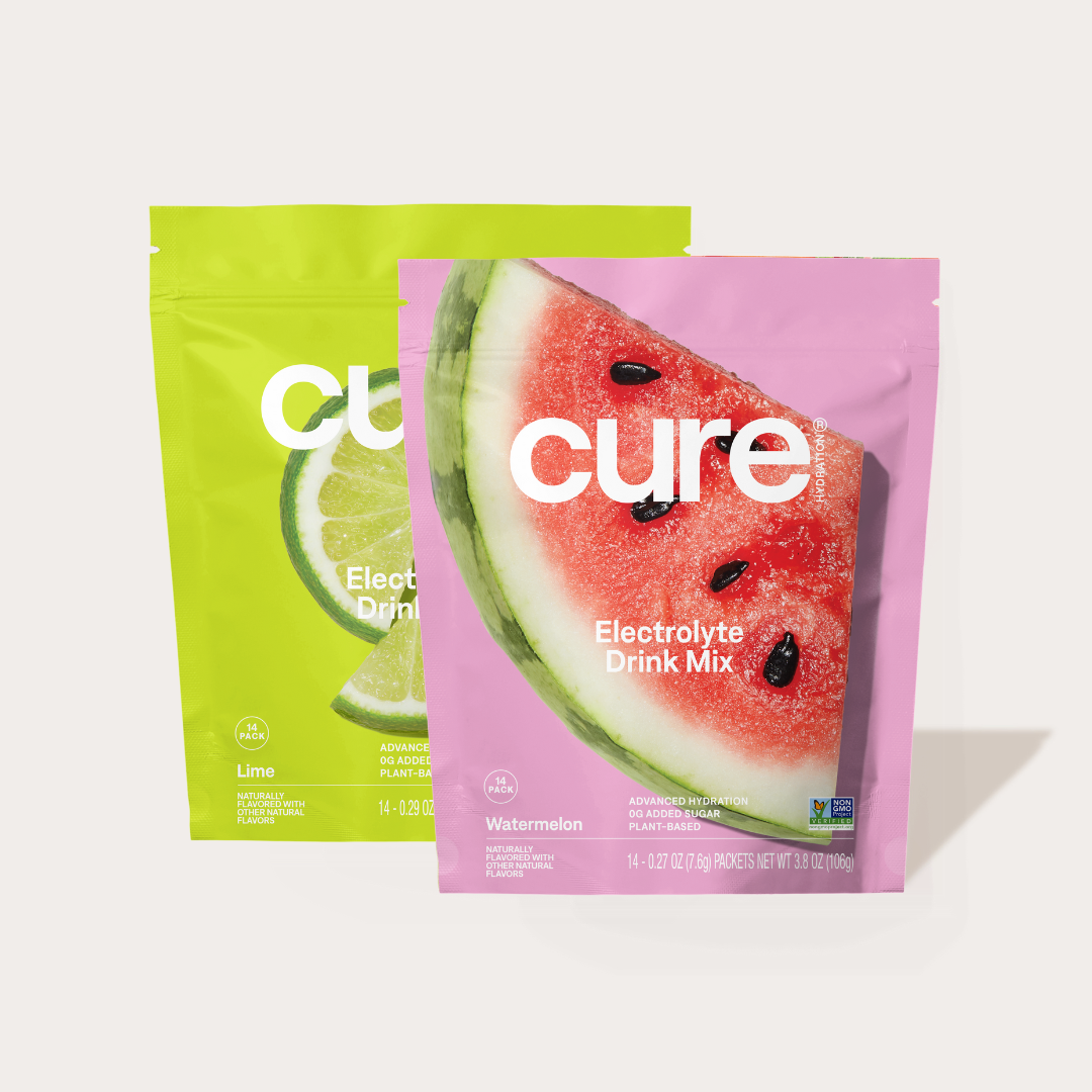 Two Cure Electrolyte Drink Mix packets, one Watermelon flavor and one Lime flavor, with visible text 'cure Electrolyte Drink Mix Watermelon Lime'.